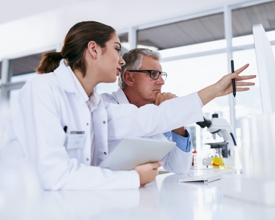 A woman and a man wearing lab coats discussing